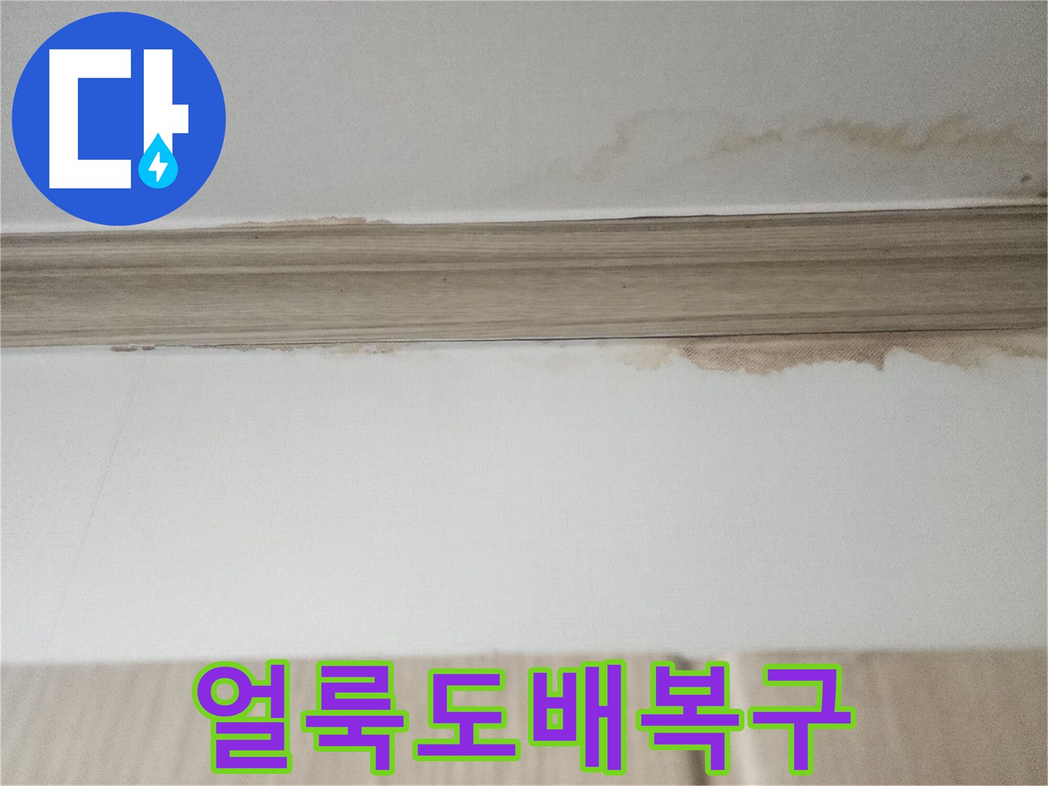 천장 몰딩 아래쪽으로-물이 스며들어 생긴-얼룩은-누수 해결 후-도배 복구가 필요함을-보여줍니다.