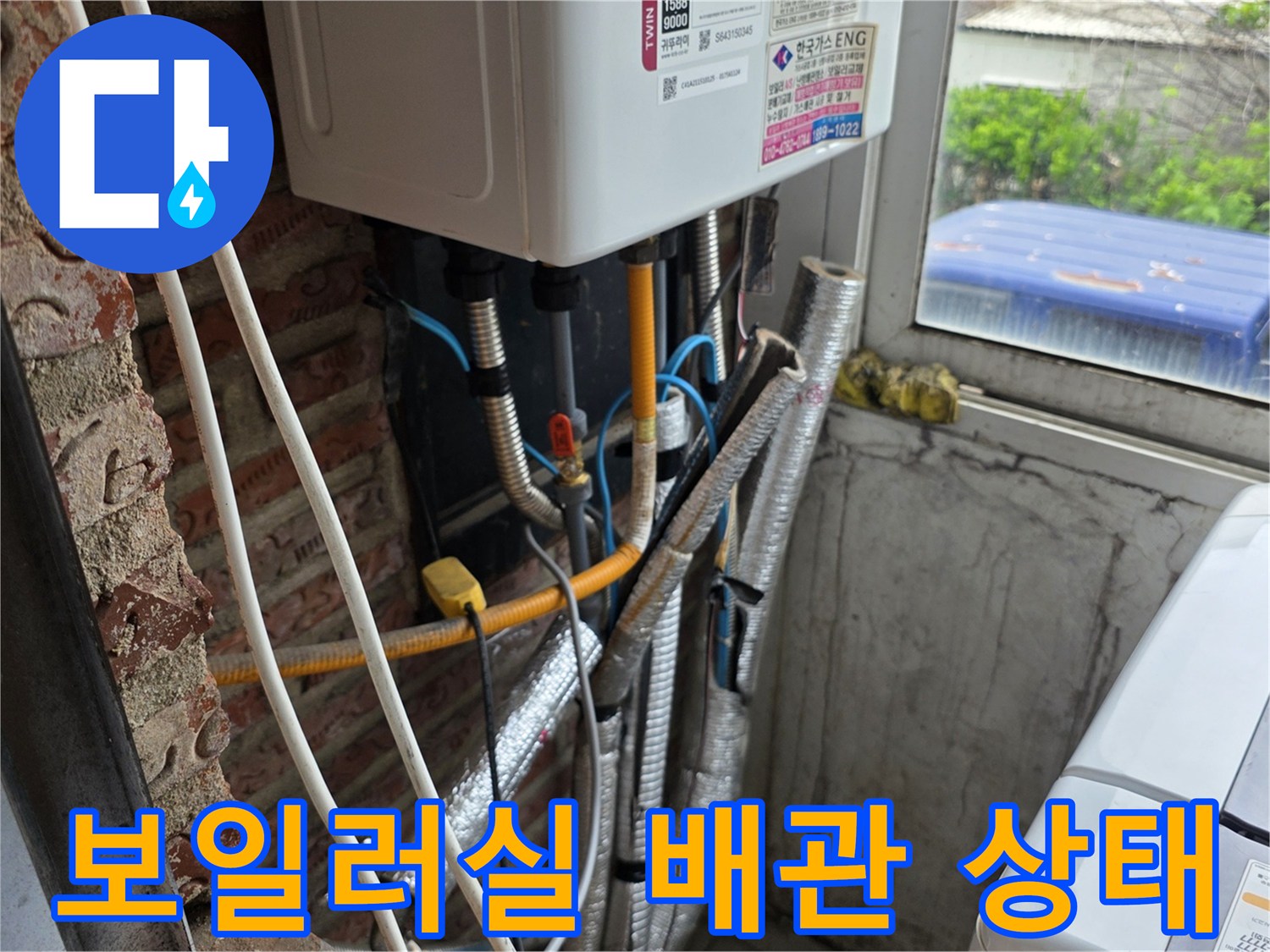 보일러 하단에 노출된 온수 및 직수 배관의 연결 부위 모습