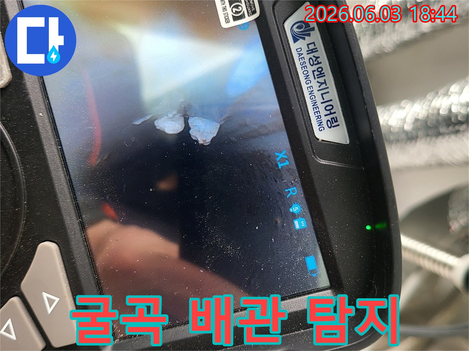 전문 엔지니어가-유연한 내시경 장비로-복잡하게 굴곡진 배관 내부를-정밀하게 탐지하여 누수 원인을 찾는 모습