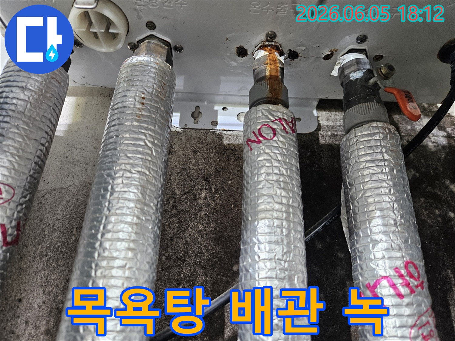 목욕탕 보일러의 온수 배관에서-심각한 녹물과 부식으로 인해-누수가 진행되고 있음을-보여주는-현장 사진입니다.
