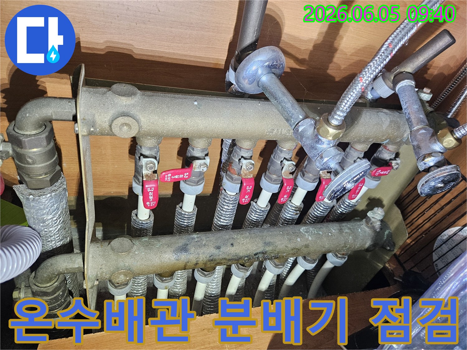 아파트 온수 배관의-분배기 시스템을-누수 엔지니어가-정밀하게 점검하며-누수 여부를-확인하는-모습입니다