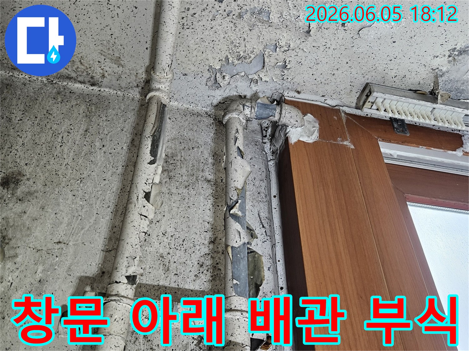 창문 아래 배관에서-물이 새어-벽면 페인트가 벗겨지고-곰팡이가 발생한 모습입니다