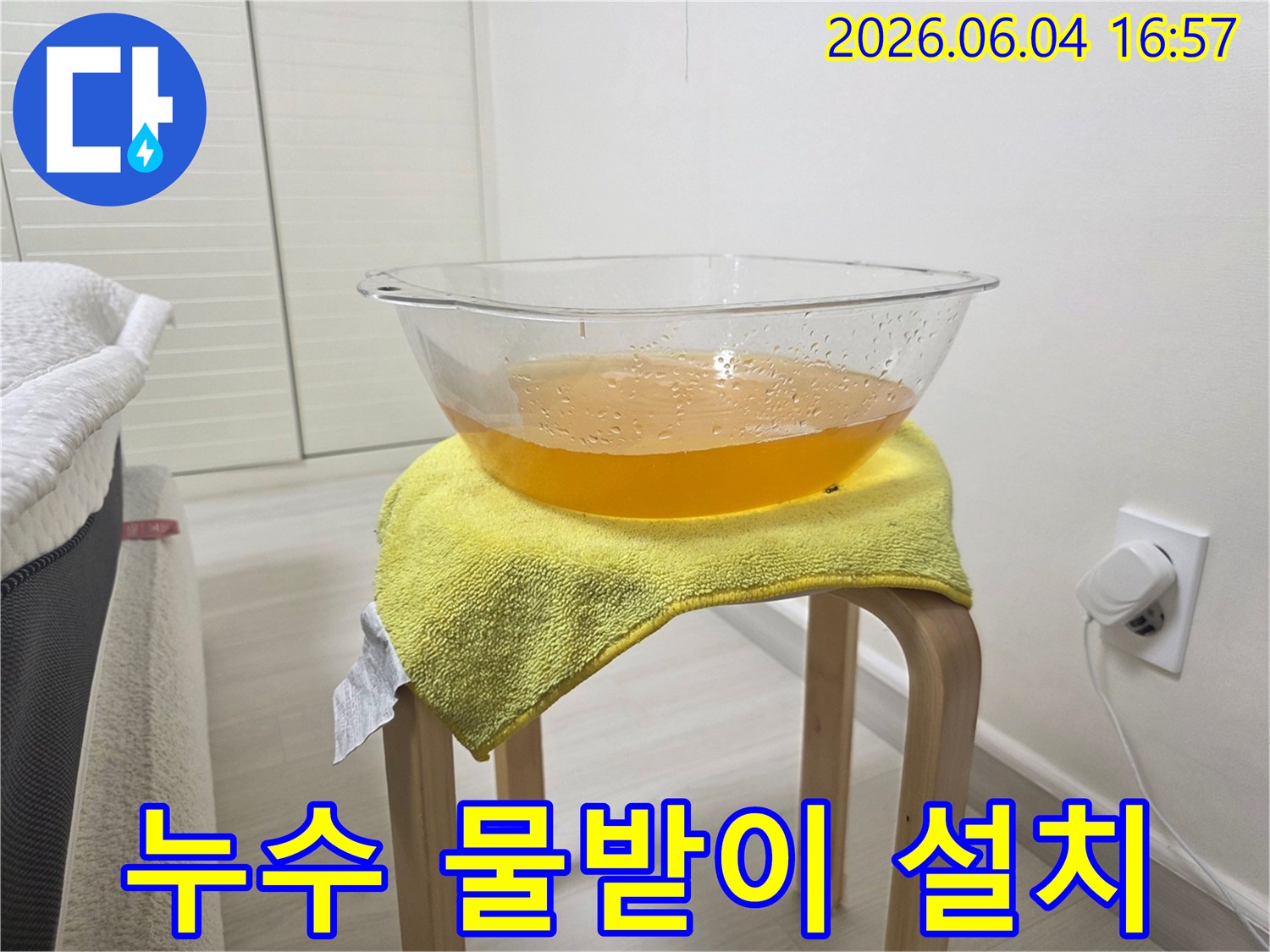누수로 인해 천장에서 떨어지는 물을-안전하게 받아내기 위해-설치된 임시 물받이의 모습