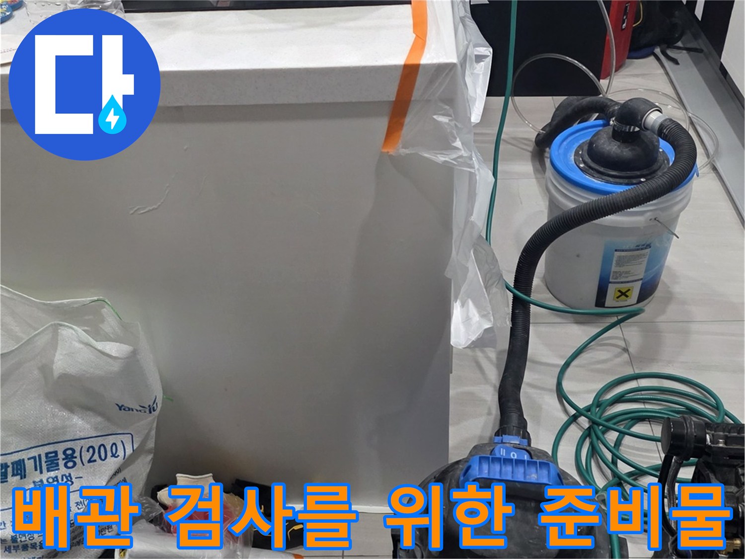 싱크대 밑바닥 배관 상태를 확인하기 위해 배치한 각종 공구와 장비