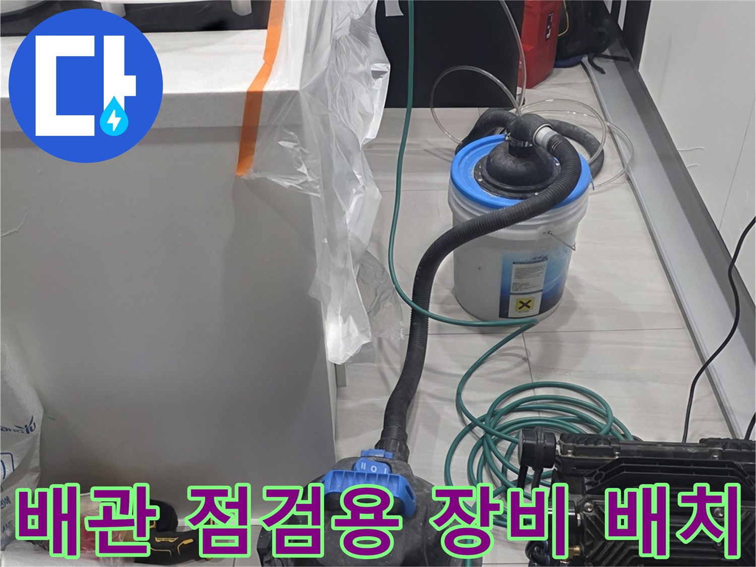 싱크대 아래 배관 상태를 확인하기 위해 세팅된 압력계와 청소기