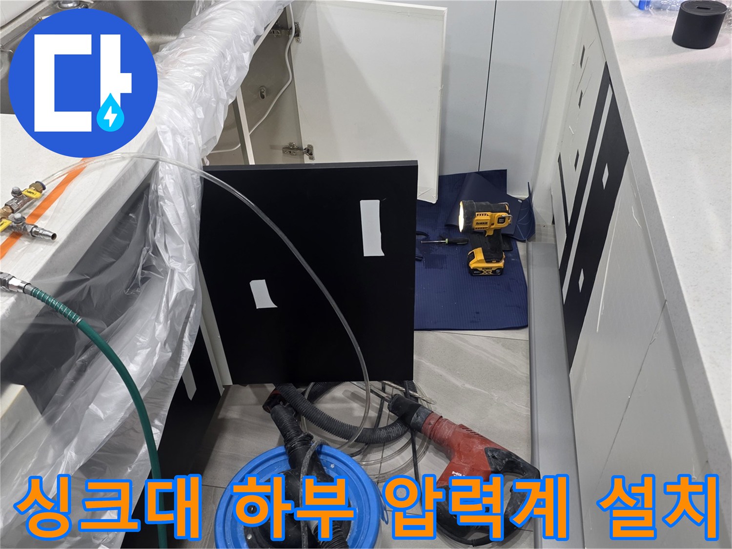 주방 싱크대 하부 배관 진단을 위해 설치된 압력 게이지와 공압 테스트 장비