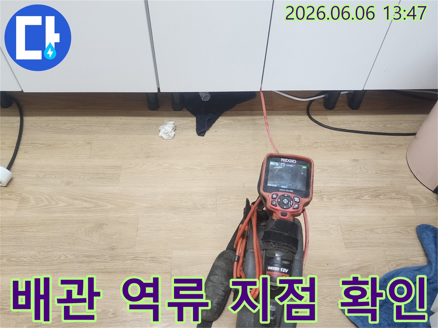 싱크대 배수관의 역류 지점을 정확하게 찾아내기 위해-내시경 장비를 활용하여 검사하는 모습