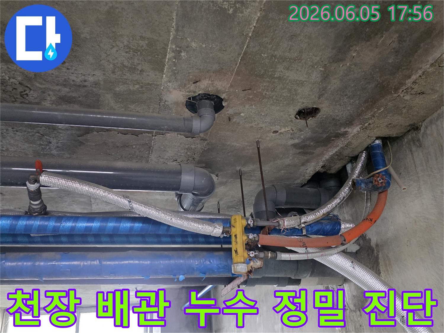 콘크리트-천장-아래-설치된-다양한-배관들의-복잡한-모습-누수-탐지-전문가가-현장을-면밀히-조사하고-있습니다