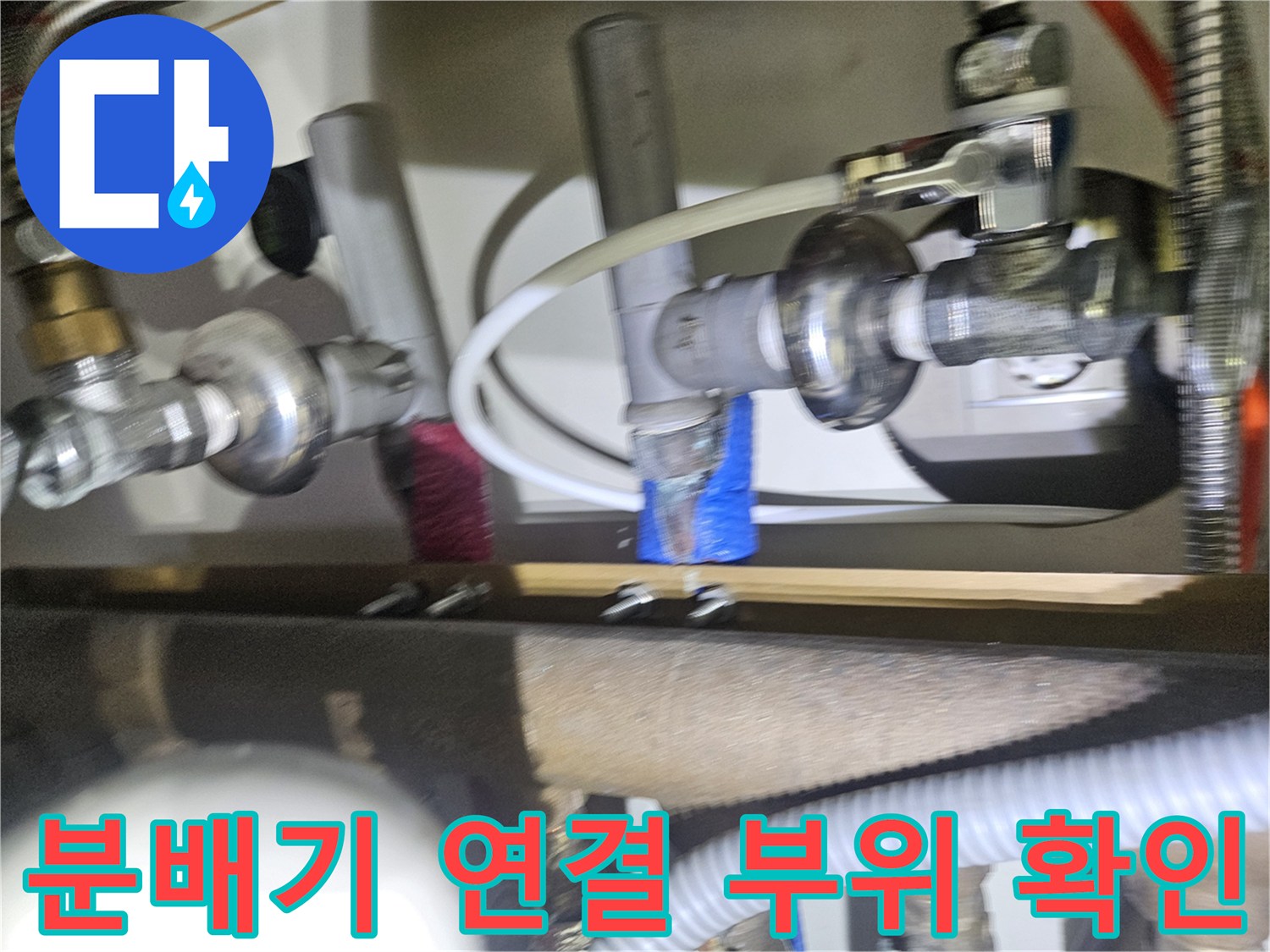 금속제 난방 분배기와 엑셀 파이프가 연결된 싱크대 하부 배관 모습