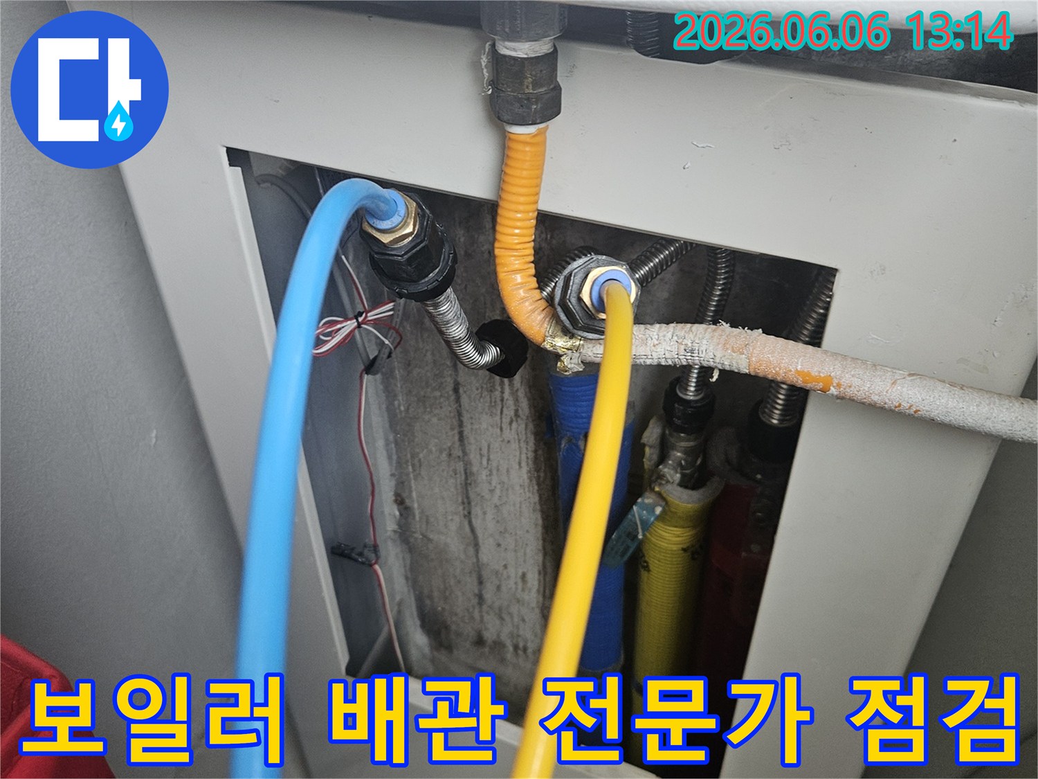 보일러 하단에 연결된 복잡한 배관 시스템을-누수 전문가가 꼼꼼하게 점검하며 누수 여부를 확인하는 모습
