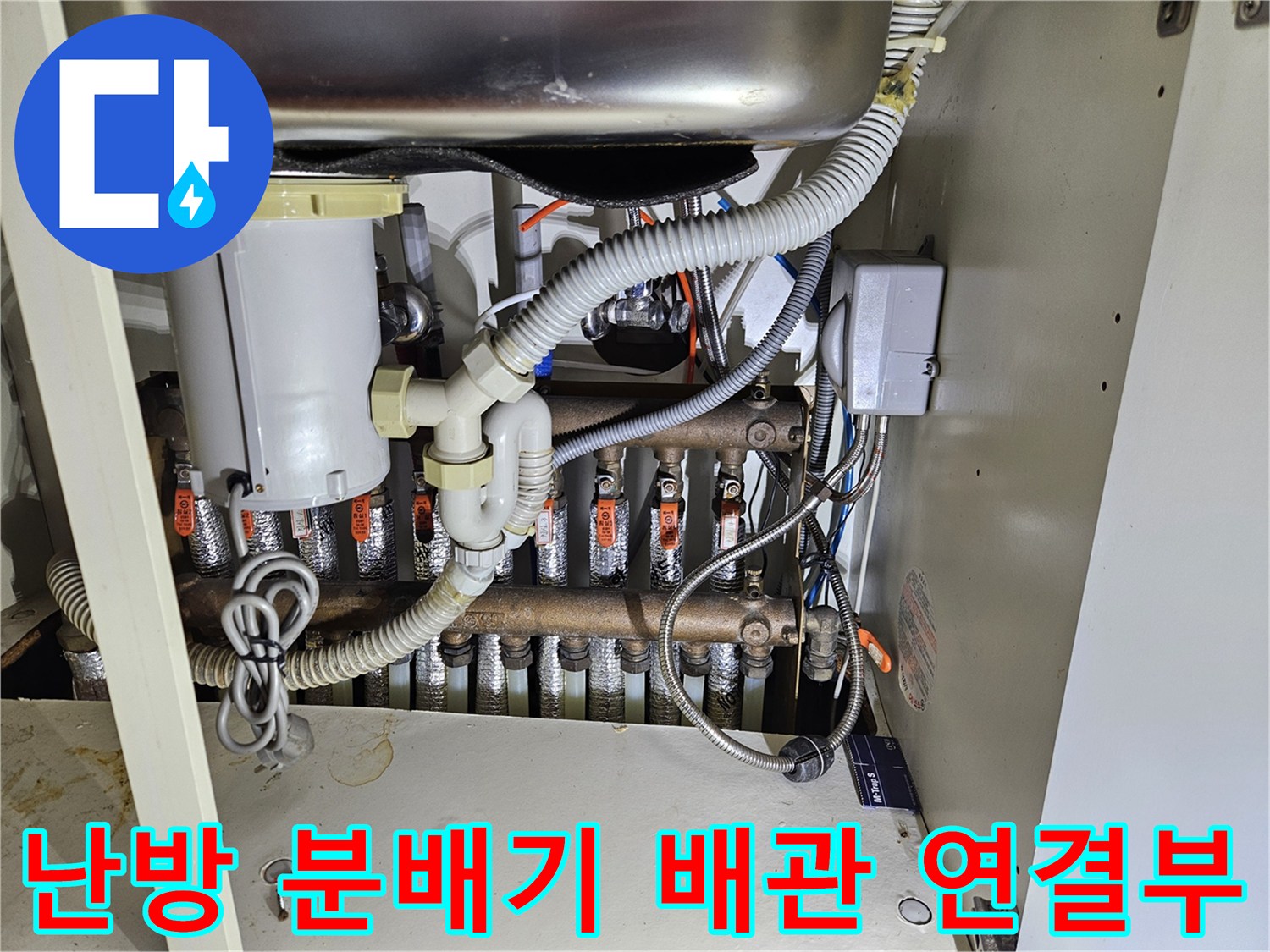 싱크대-하부장-내부-금속제-난방-분배기와-연결-배관들