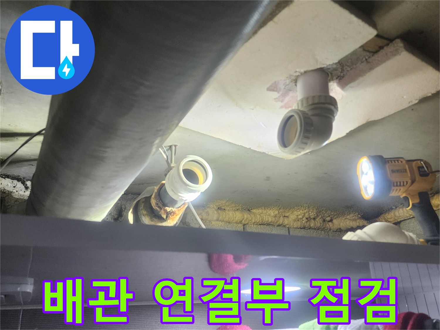 누수-전문가가-배관의-연결-부위를-집중적으로-살펴보며-누수-흔적을-찾아내는-장면