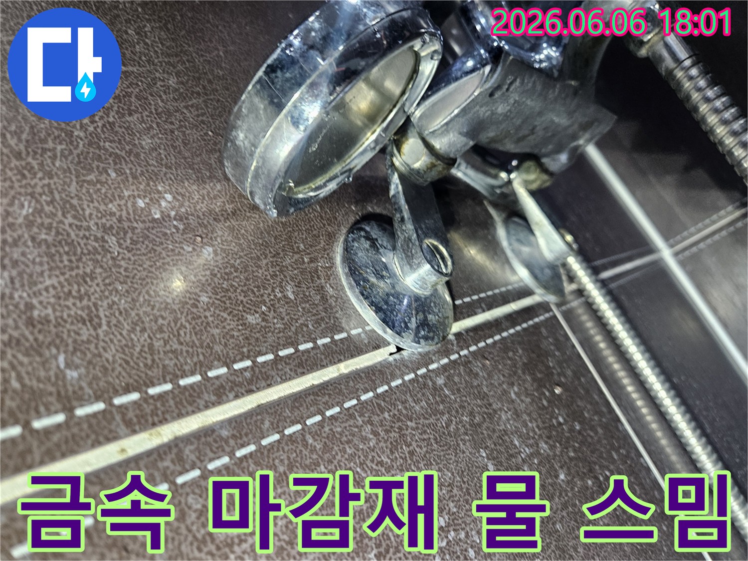 바닥 금속 마감재-하부에서-발생한-물 스밈 현상으로-타일이 변색된-누수 현장