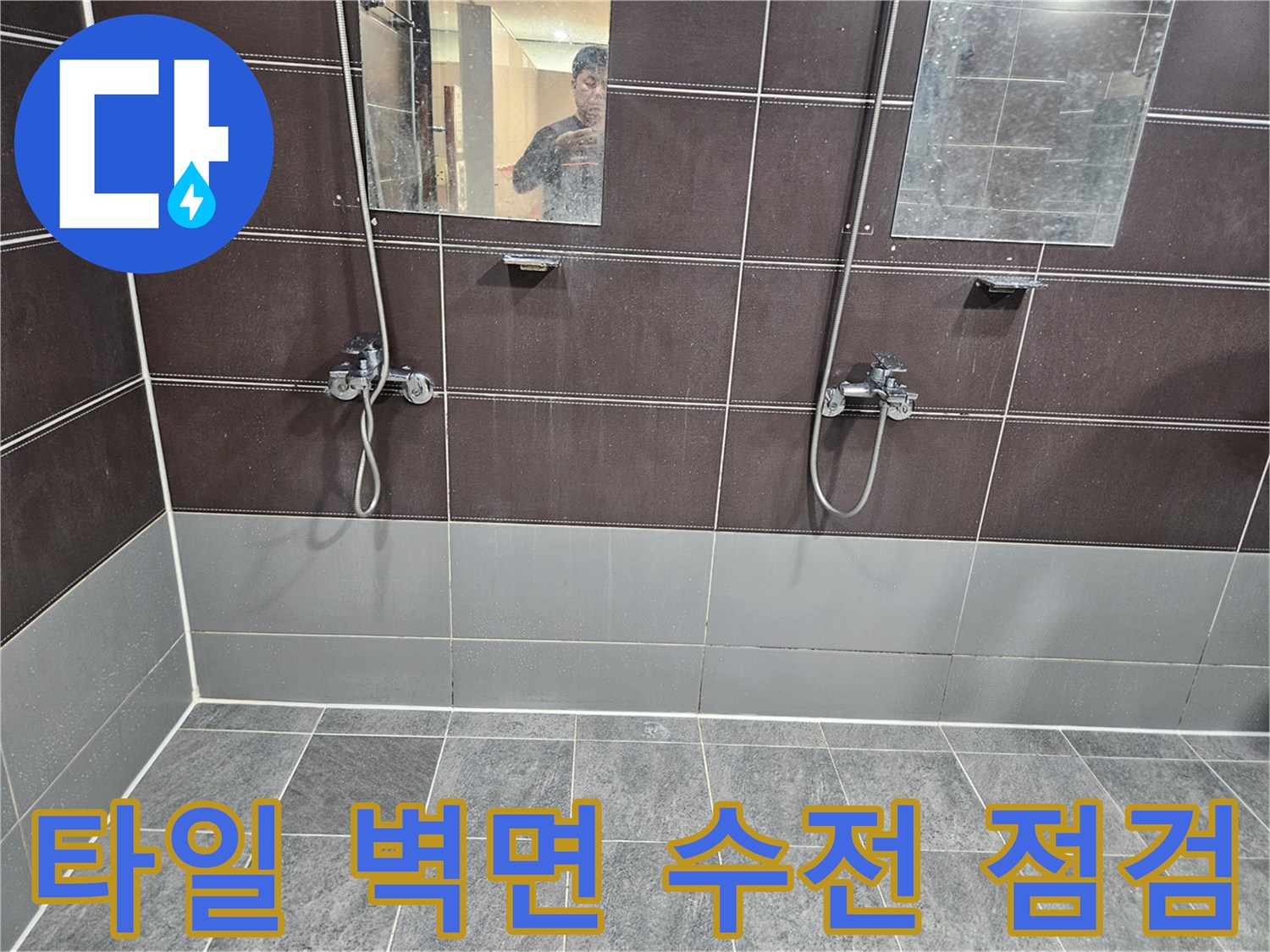 어두운 톤의 타일 벽면에 설치된 샤워 장비 근접 촬영