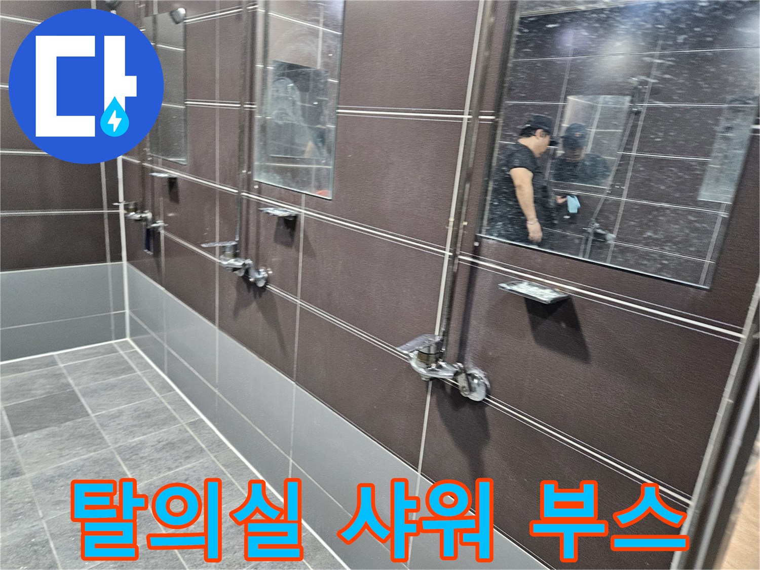 어두운 톤의 타일로 마감된 샤워실 내부 수전 설치 모습
