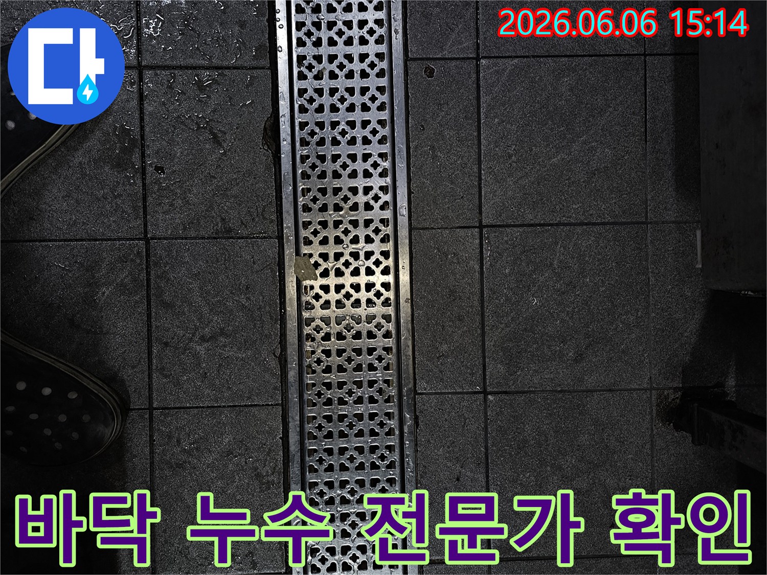 젖은 타일과 배수구가 있는 어두운 공간-누수 문제로 인한 물기 확인-전문가가 현장 상황을 파악하는 모습