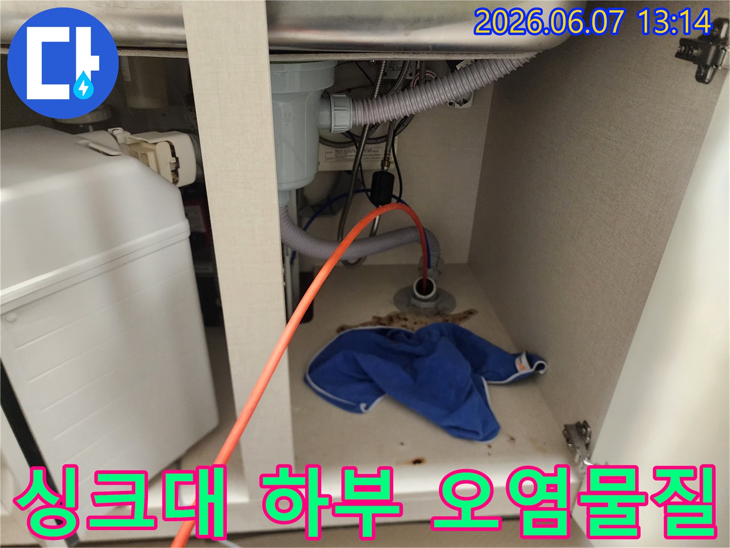 싱크대 아래 배수관 주변에 역류된 이물질과 젖은 걸레가 있는 모습입니다.