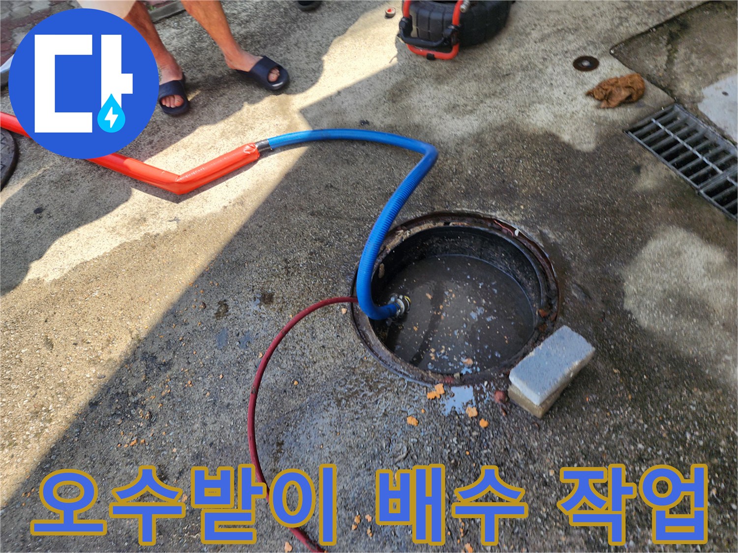 오수받이 내부의 고인 물을 제거하기 위해 배수 펌프 호스를 연결한 모습입니다.