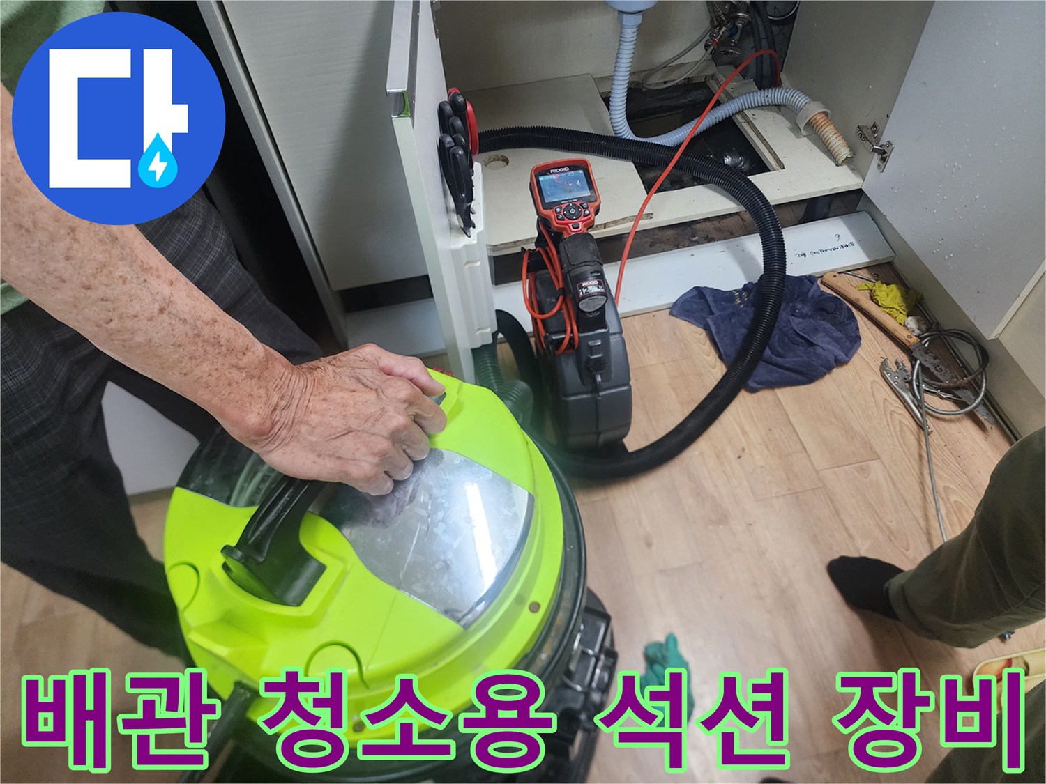 싱크대-하부장-내부에서-작업중인-석션기와-배관-연결상태