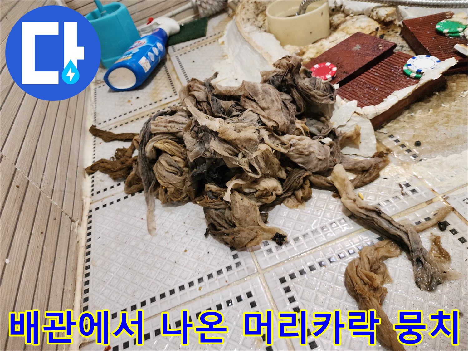 욕실 바닥 타일 위에 놓인 거대한 슬러지 및 섬유질 오염물