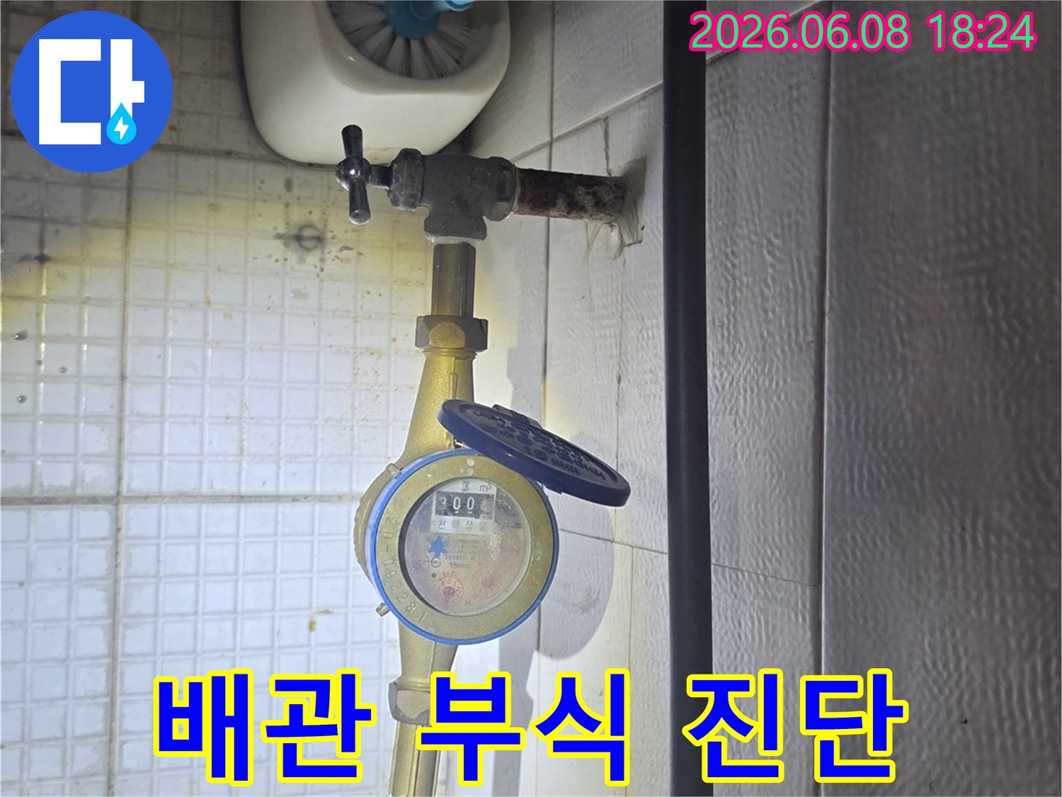 이 사진은-의정부 용민로에서-누수 엔지니어가-수도 계량기 옆-배관의 부식 상태를-정밀하게 진단하는-모습을-보여줍니다