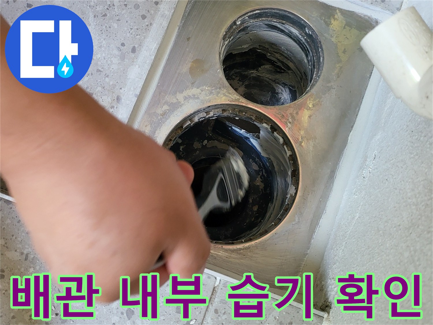 배수구 안쪽의 젖은 상태와 이물질을 면밀히 관찰하는 작업 장면