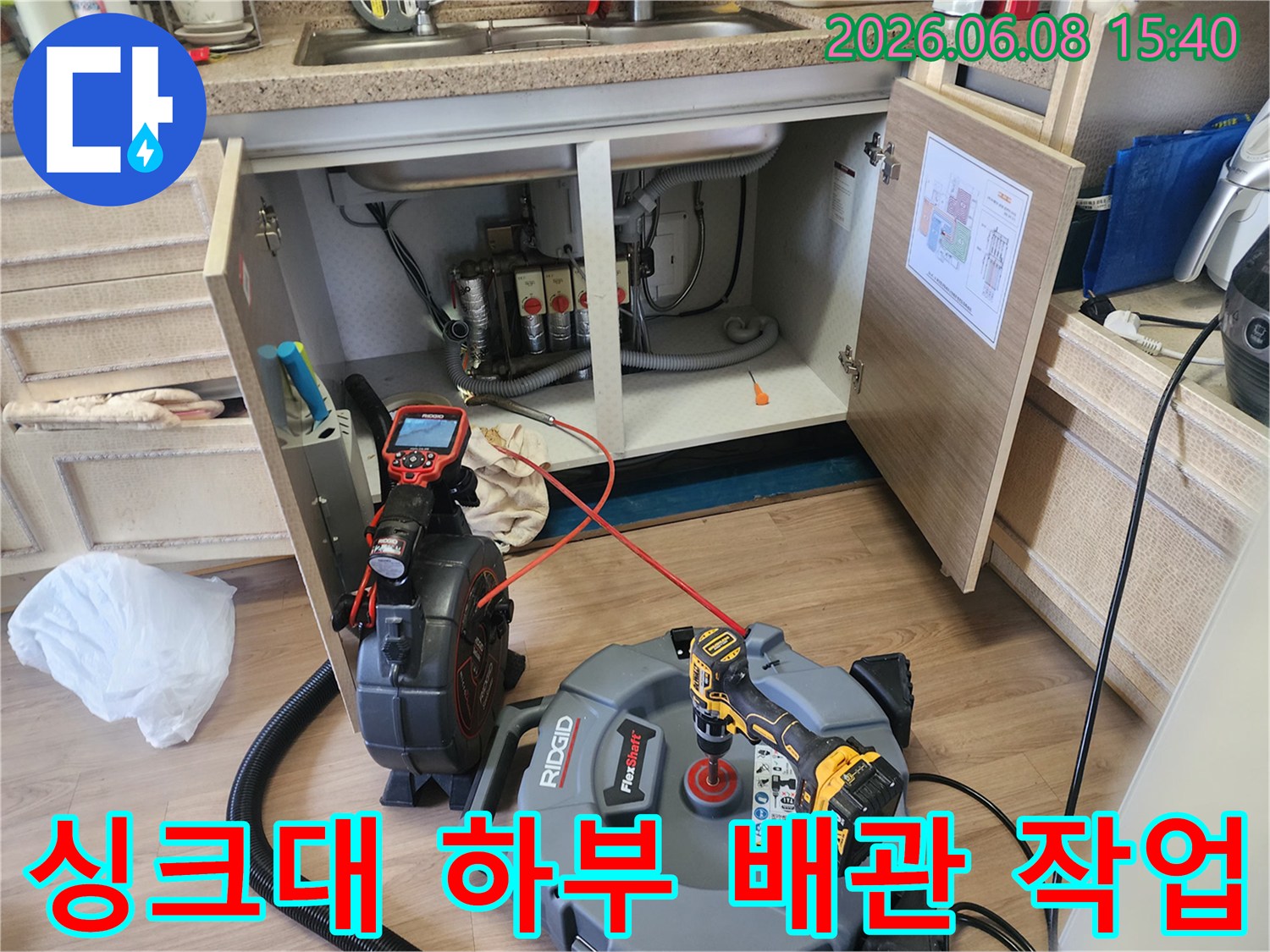 남양주 덕소동 싱크대 하부장 내부에서 진행 중인 배관 스케일링 장비 모습