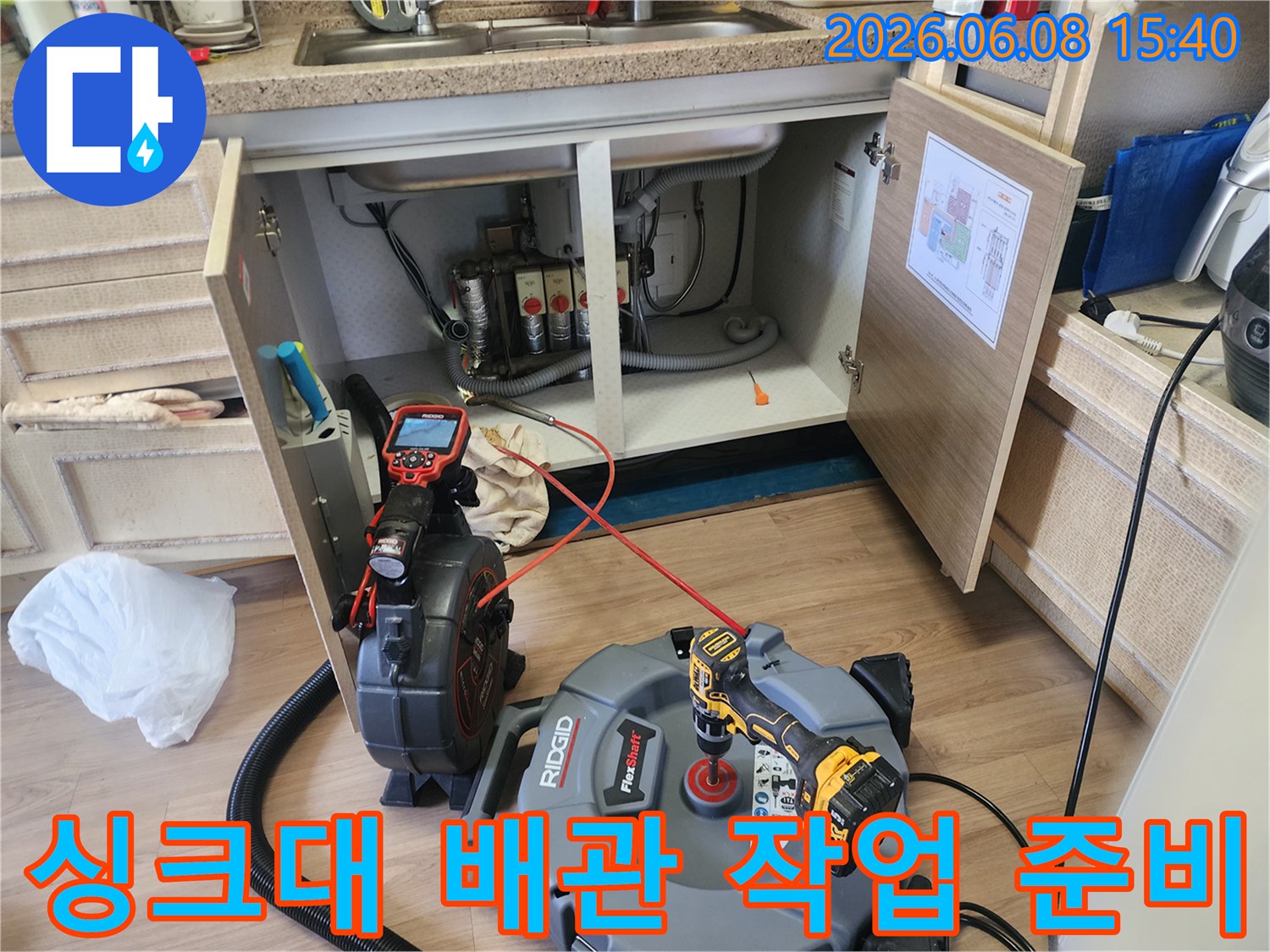 싱크대 밑 공간에 설치된 배관 내시경 카메라와 석션 장비 세트