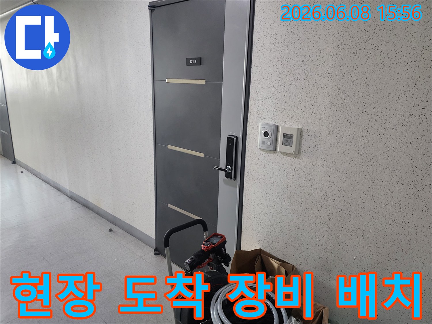 복도 입구에 놓인 배관 청소용 석션 장비와 호스