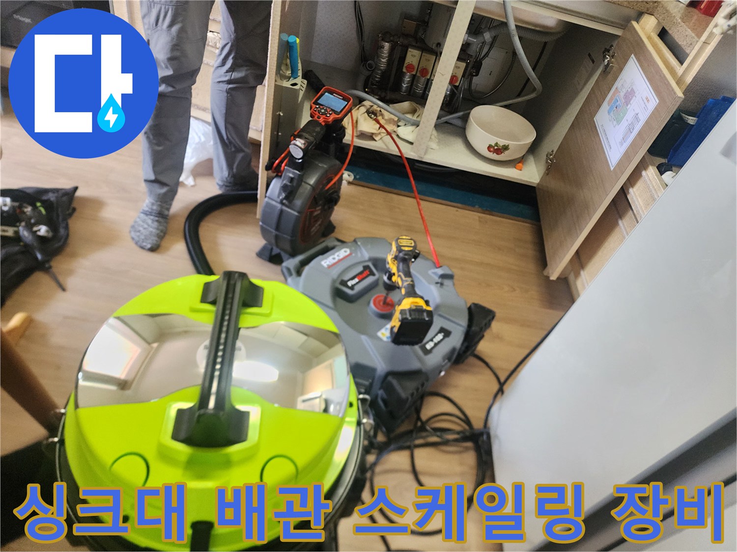 싱크대 하부장 아래 설치된 배관 스케일링 및 석션 장비 모습