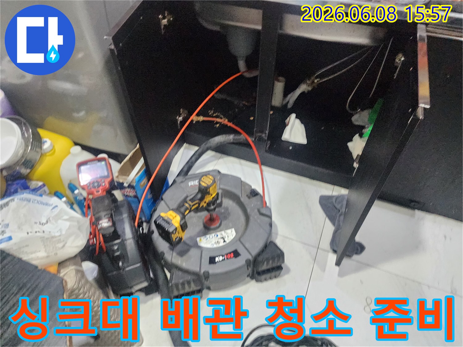싱크대 하부 공간-막힌 배관을 뚫기 위해 배치된 작업 도구들