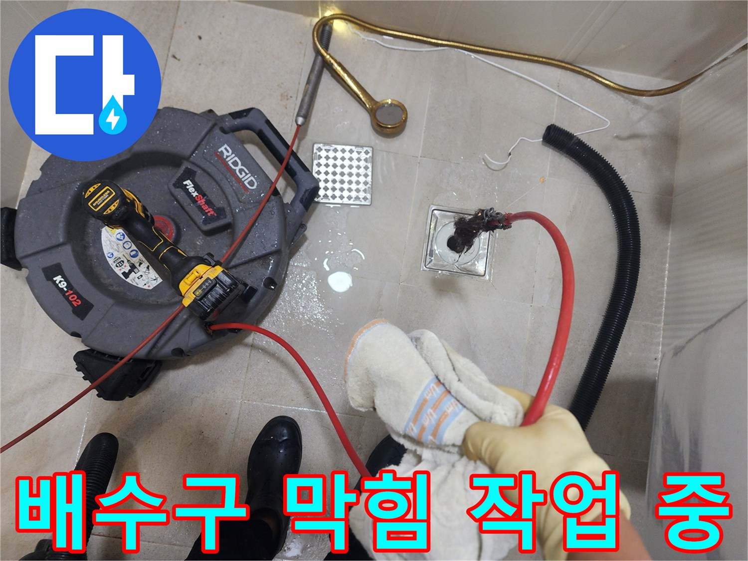 화장실 바닥 배수구에 장비를 투입하여 청소하는 현장 사진