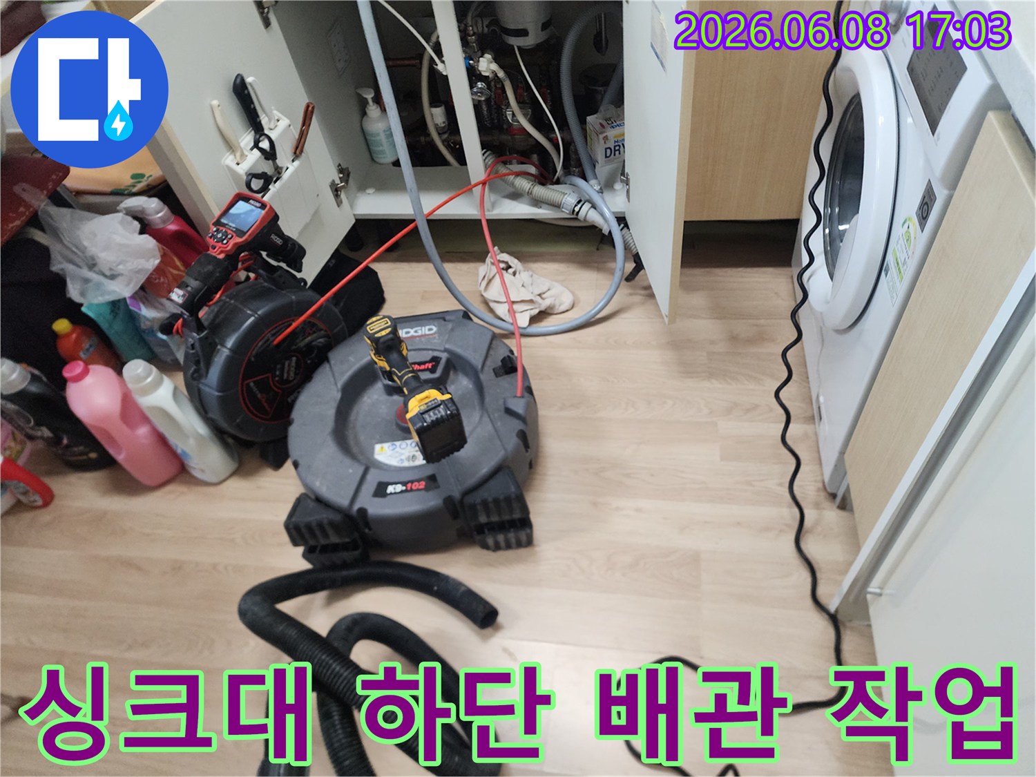 남양주 평내동 싱크대 하단에서 진행 중인 배관 스케일링 장비와 배수관 모습