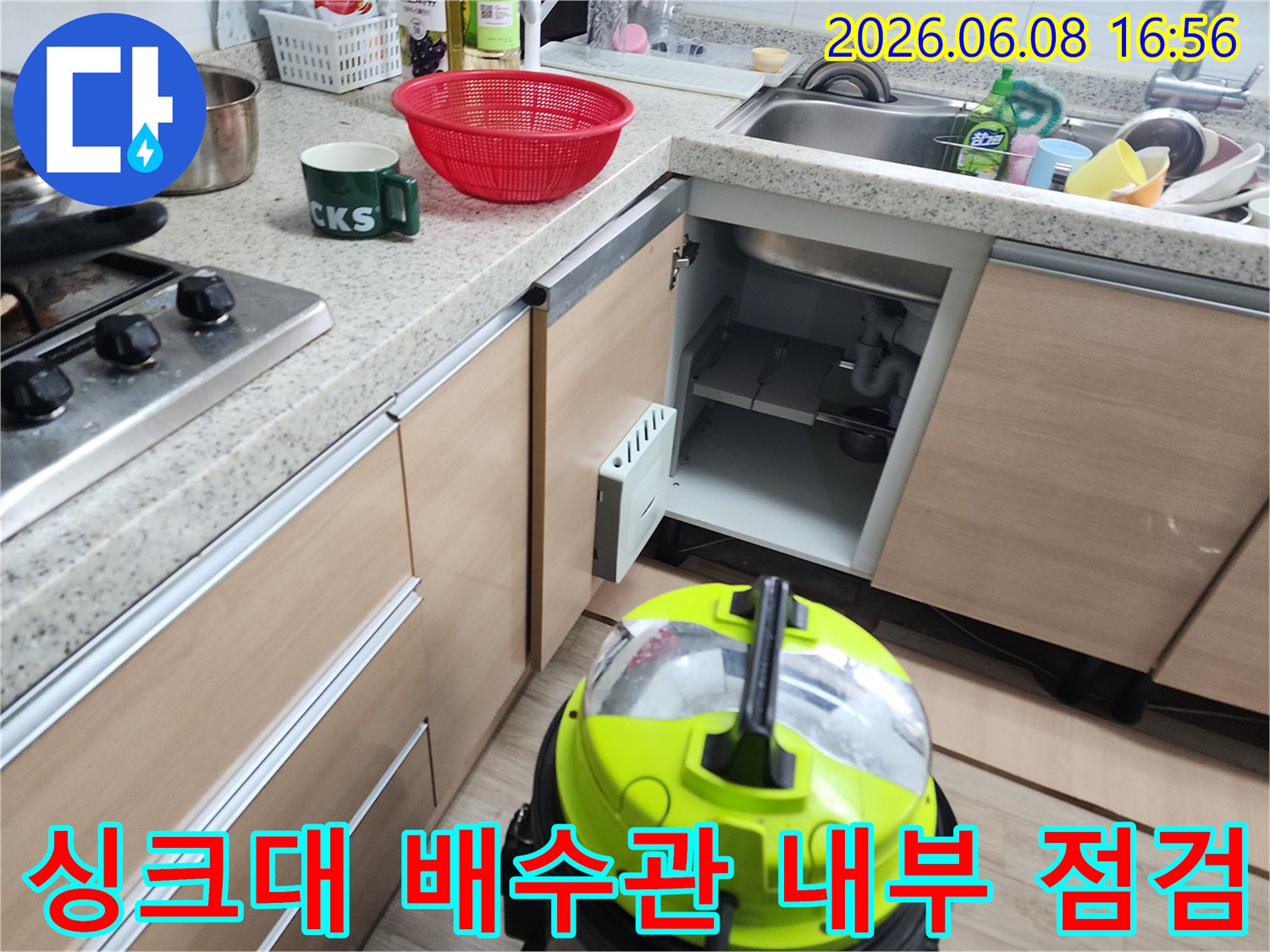 싱크대 하부장 배수구 연결 부위와 석션기 작동 준비 상태입니다.