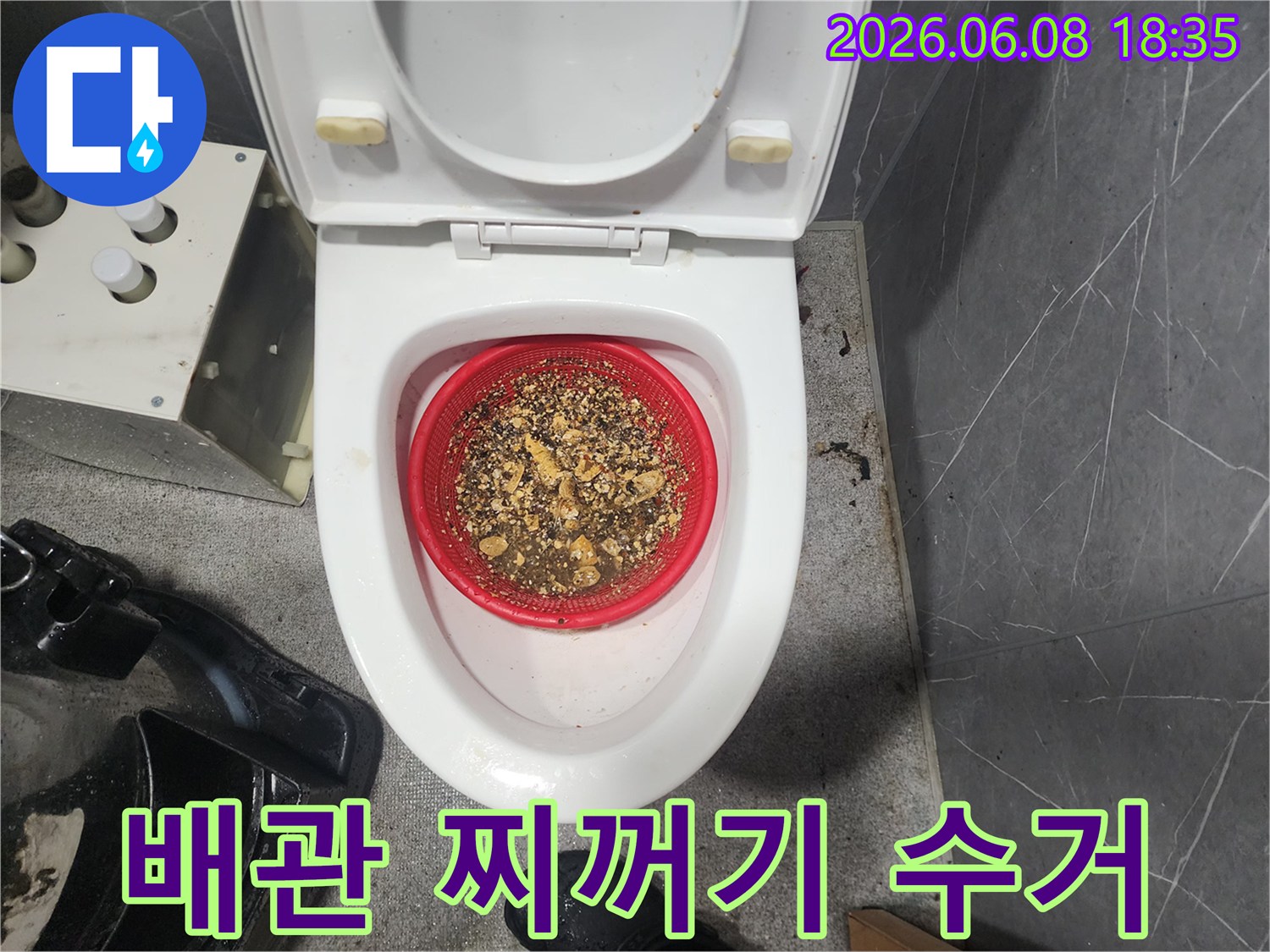 빨간 거름망에 쌓인 변기 배관 슬러지 조각들