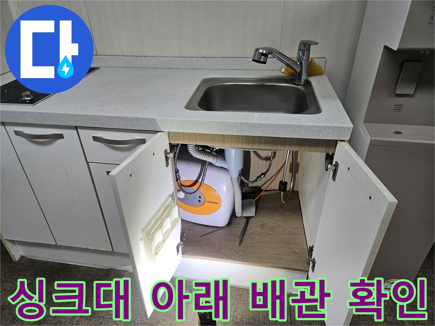 싱크대 수전 아래쪽 세탁기 호스와 배수관의 모습