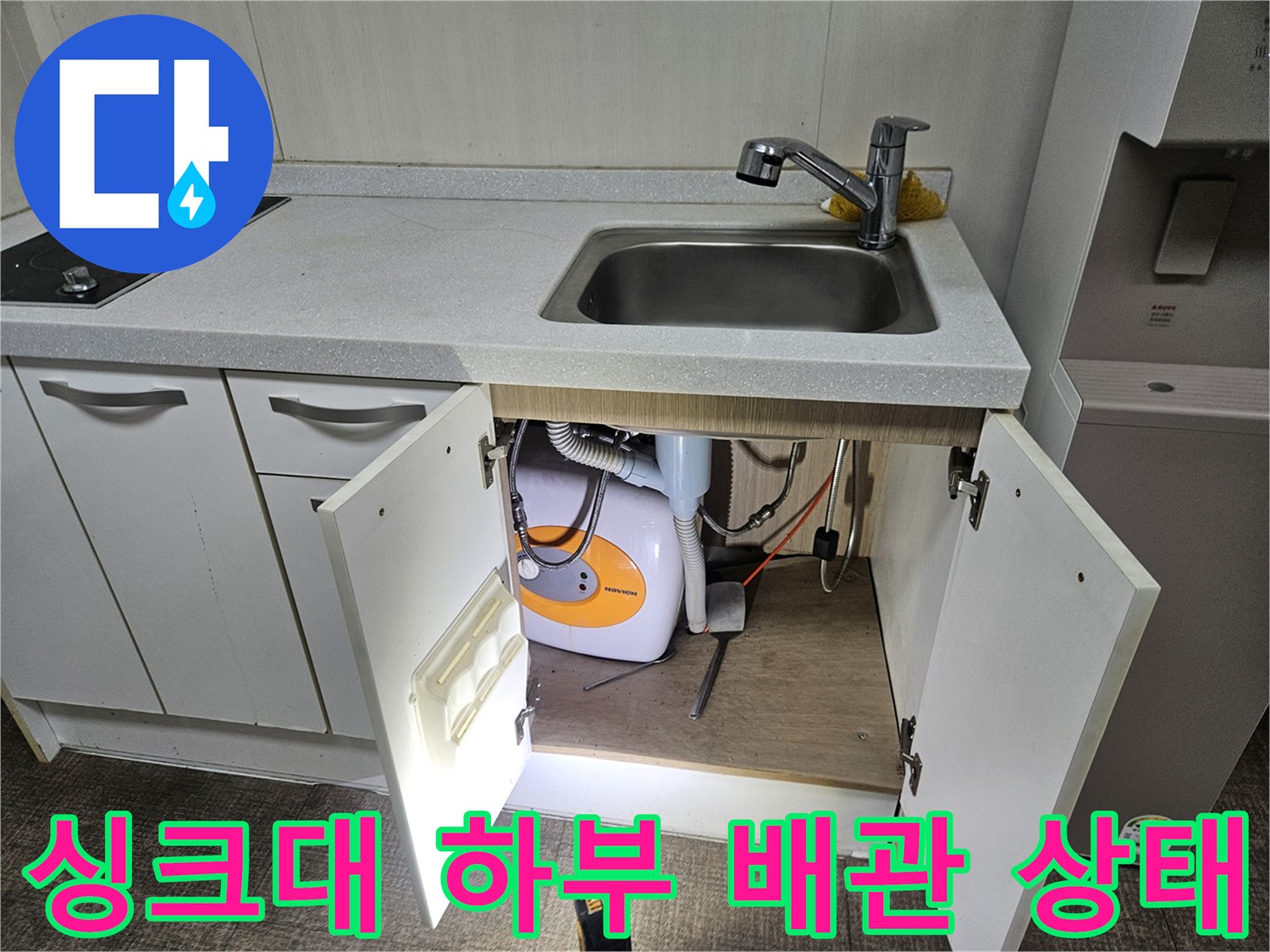 싱크대 아래쪽 수전과 세탁기 배수 호스 연결 모습
