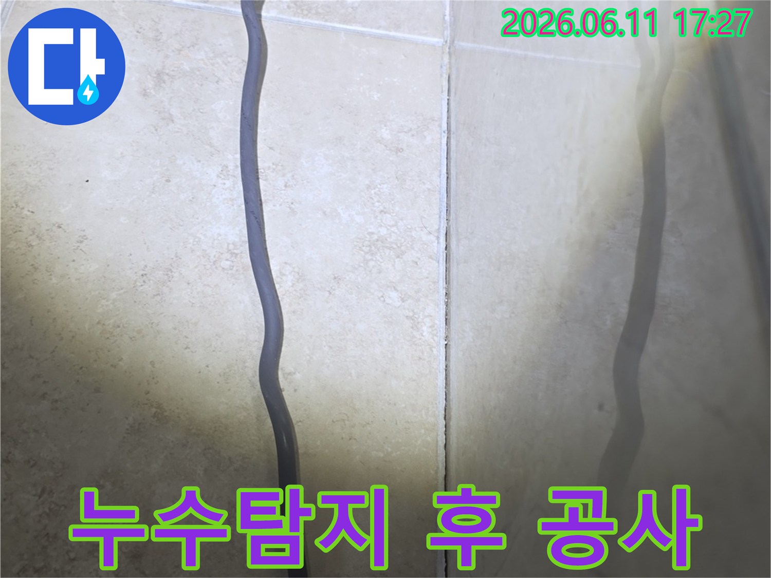 안양 아파트 누수 현장에서-누수탐지 후-공사 계획 수립을 위한-타일 틈새의 물기 흔적을-확인하는 사진입니다