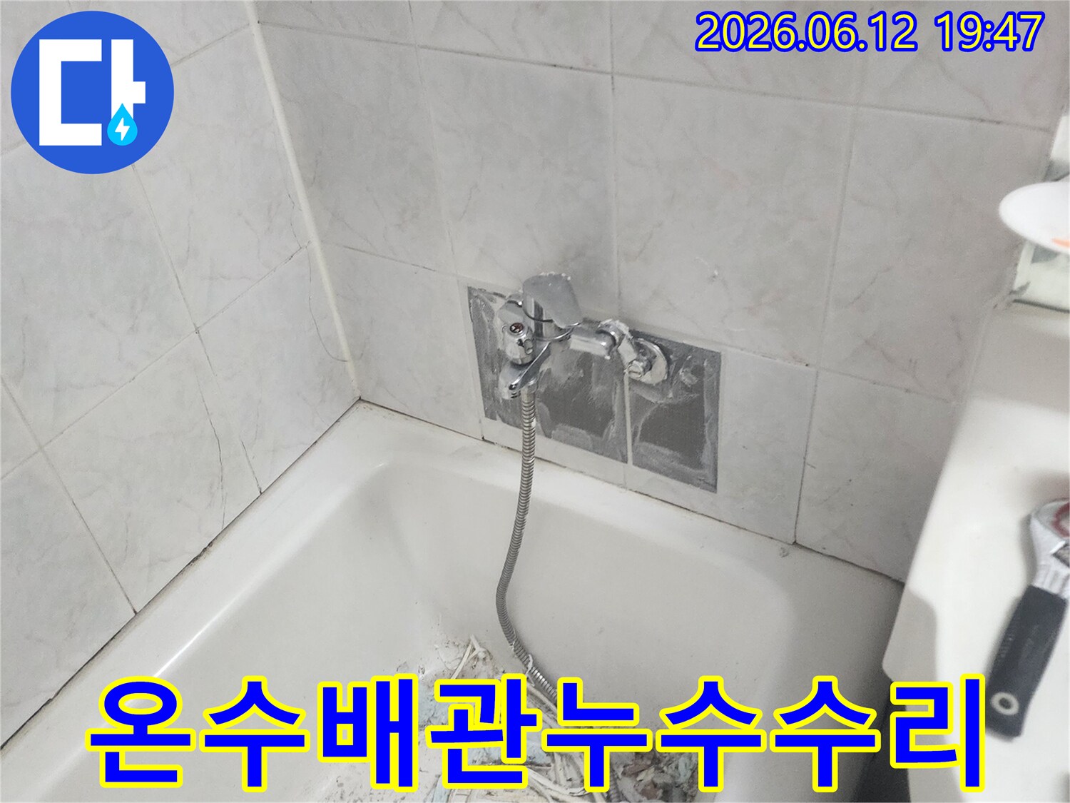 욕실 온수 배관에서 발생한 누수를 해결하기 위해 벽면 타일을 제거하고 파열된 배관을 교체하는 모습 - 신속한 조치가 중요합니다
