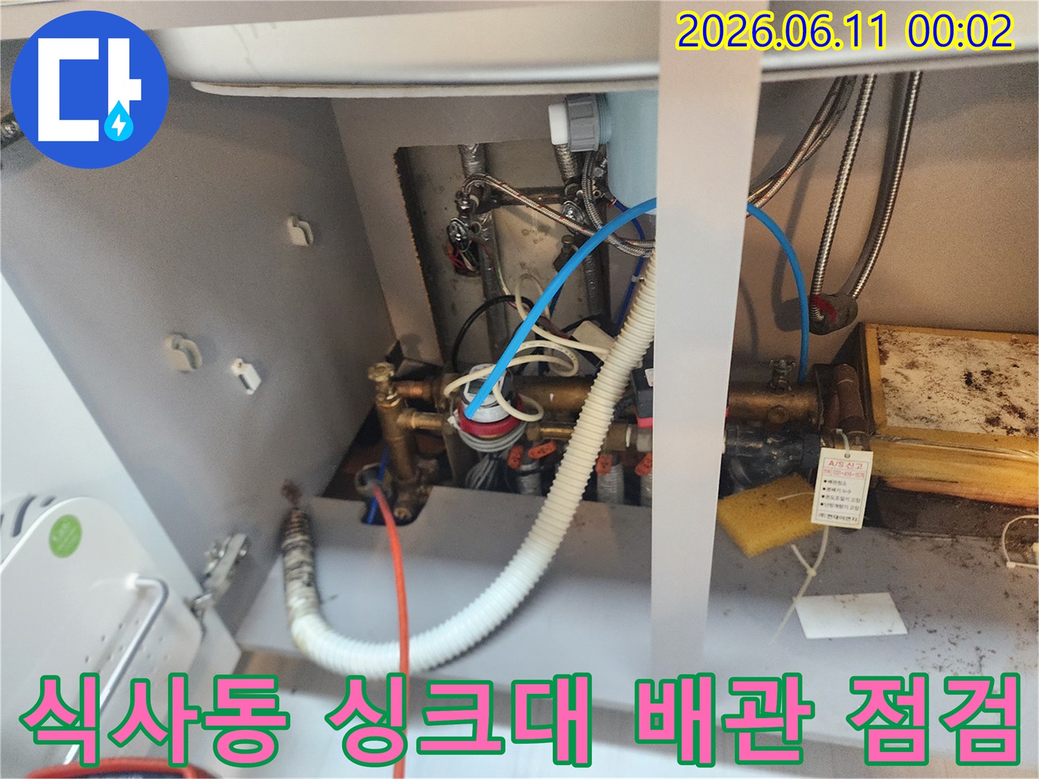 고양시 식사동-싱크대 하부장 내부의 복잡한 배관과 호스 상태를 확인하는 모습