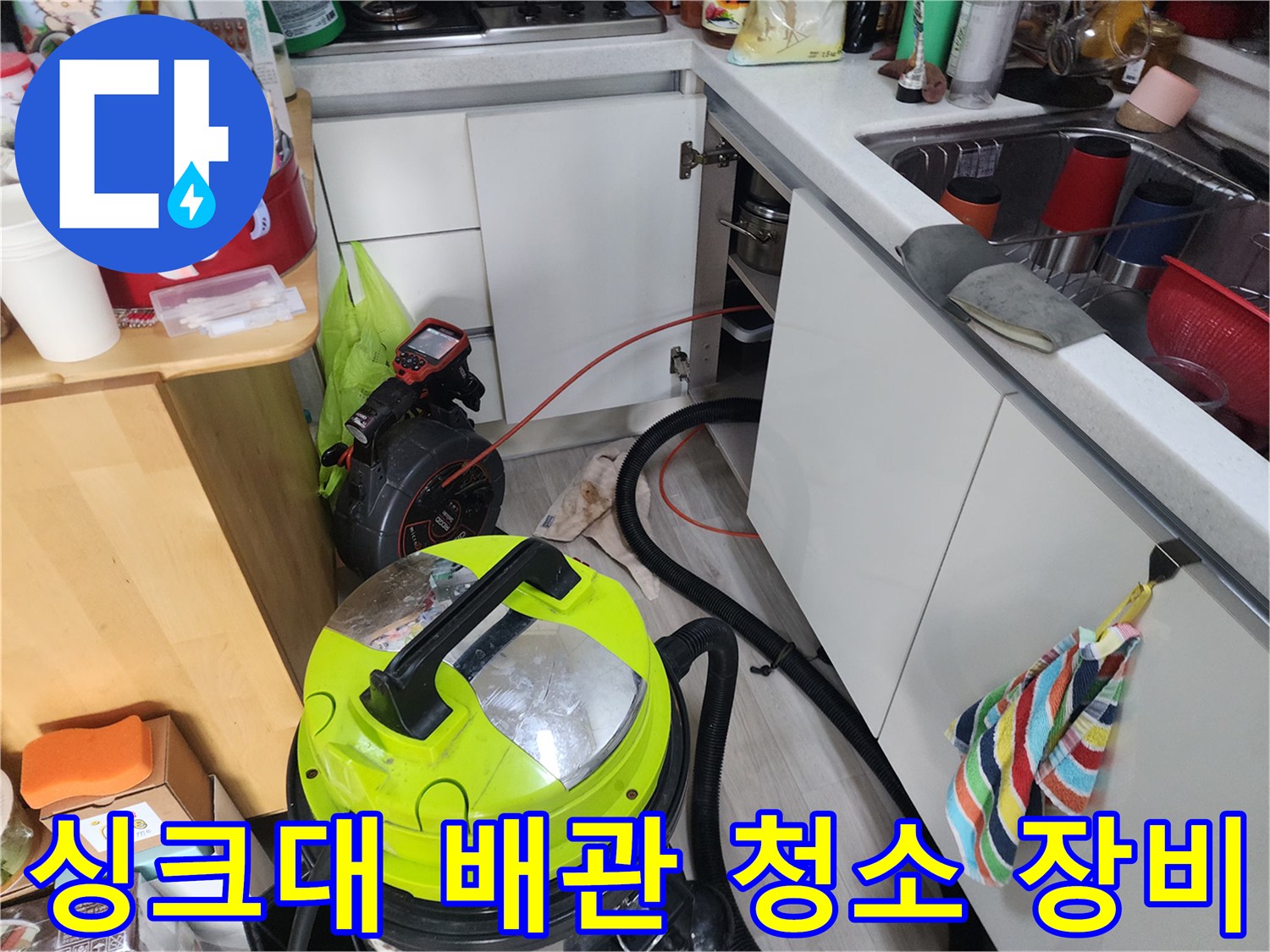 주방 싱크대 아래쪽 공간에서 배관 내부의 찌꺼기를 흡입하기 위해 준비된 전문 석션기