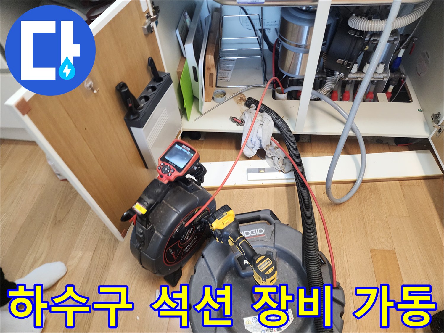 싱크대 하부장 내부의 막힌 배관을 뚫기 위해 사용되는 석션기와 내시경 장비입니다.
