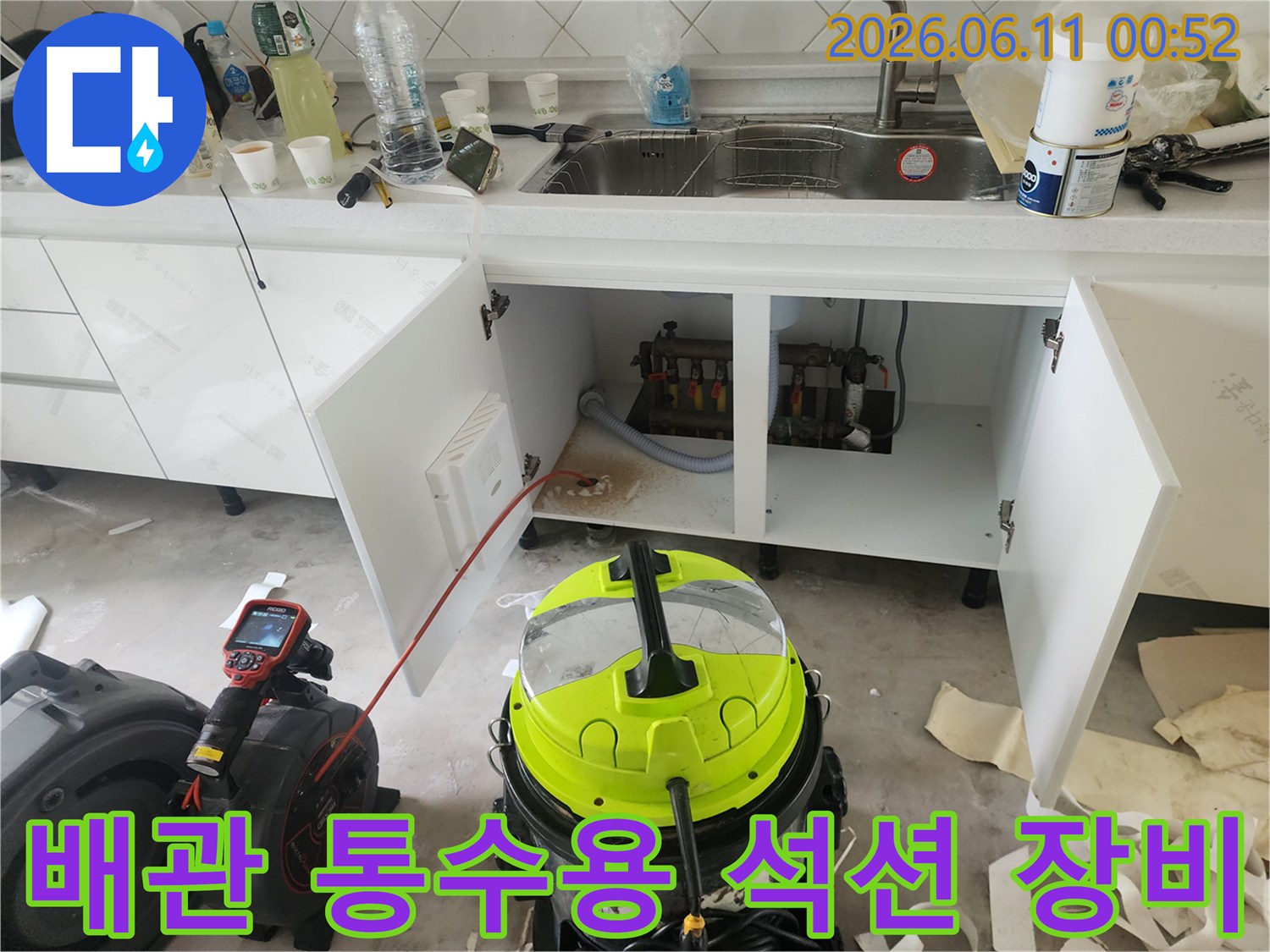 작업 중인 싱크대 아래쪽-배관 청소를 위해 준비된 진공 흡입기