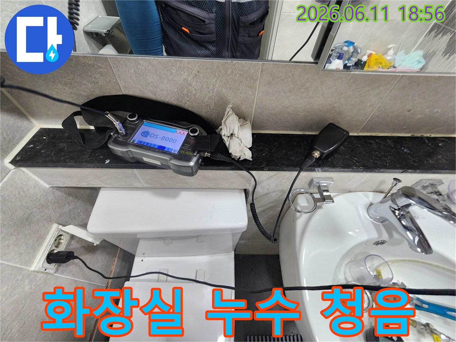 누수-탐지-엔지니어가-화장실에서-청음-장비를-이용해-배관-누수-소리를-듣고-있는-모습