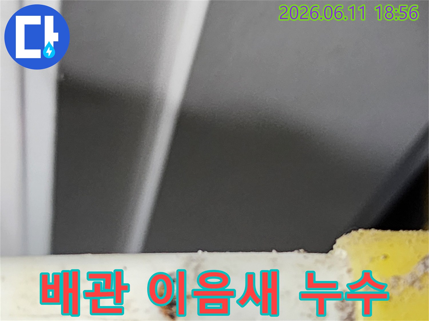 배관의 이음새 부분에서 발생한-누수 지점을-전문가가 정밀하게 확인하고-보수 작업을 준비하는 현장 사진입니다.