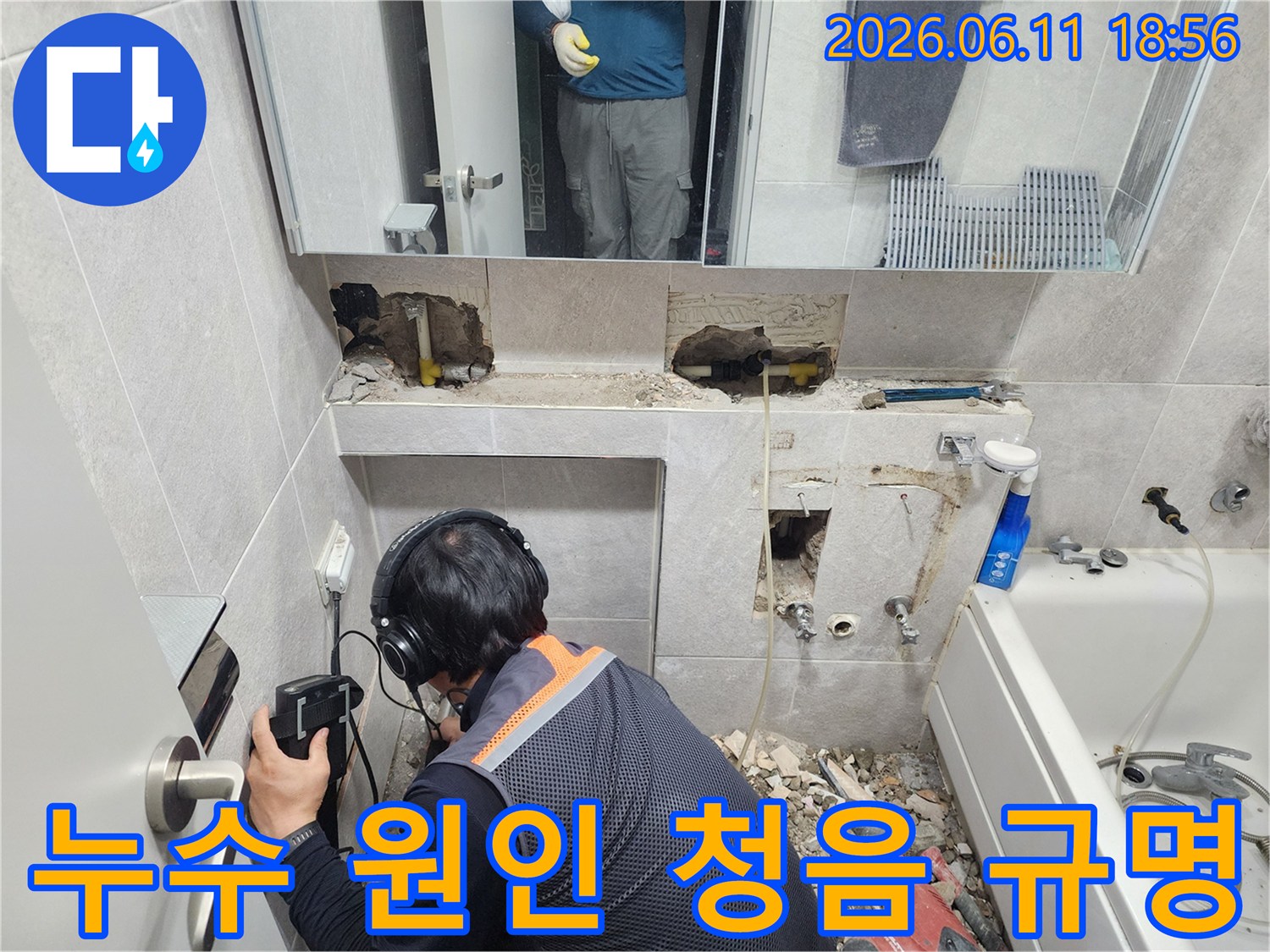 엔지니어가-특수 청음 장비를 활용하여-욕실 벽면에서-누수 소리를 집중적으로 듣는 모습