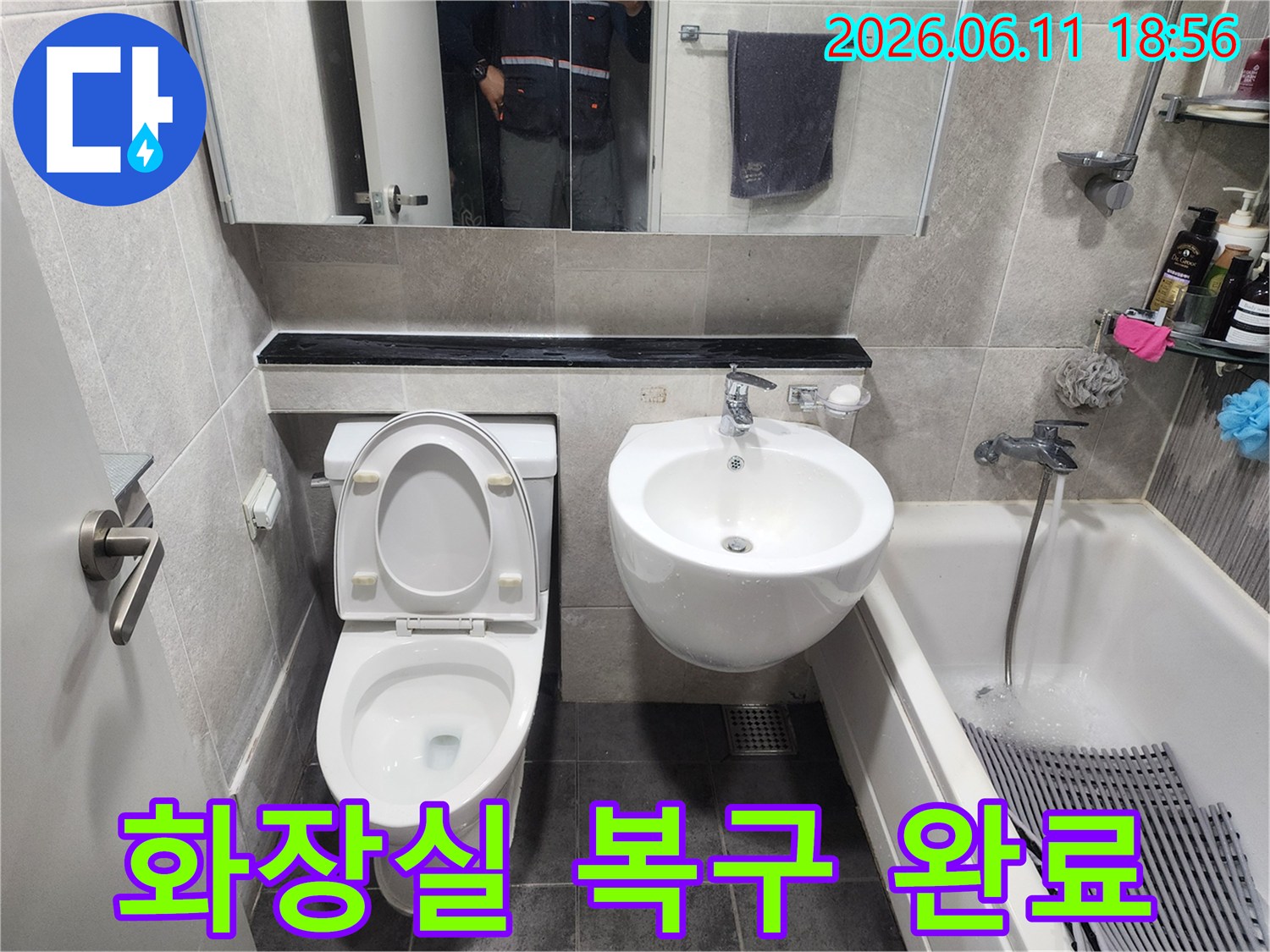 제기동 아파트 욕실의-누수 수리 작업이 완료된 후-새로운 타일로 마감하고-변기와 세면대를-깔끔하게 재설치한 모습입니다.