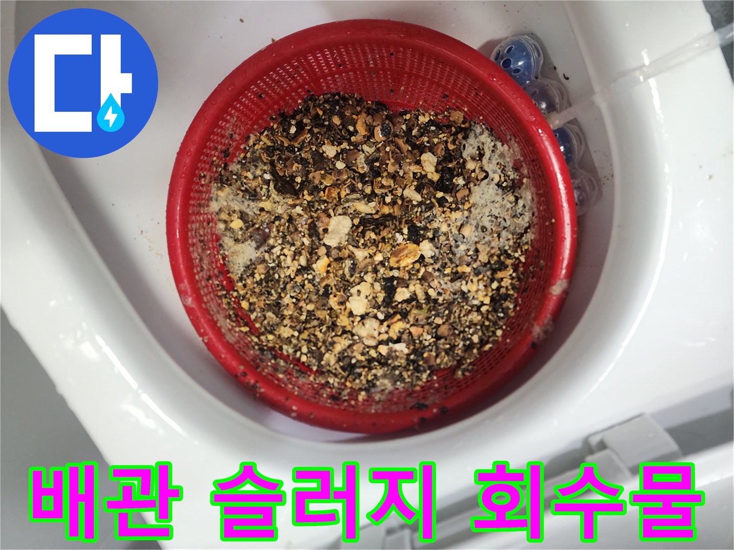 붉은색 거름망에 가득 모인 검은색 기름 슬러지 찌꺼기