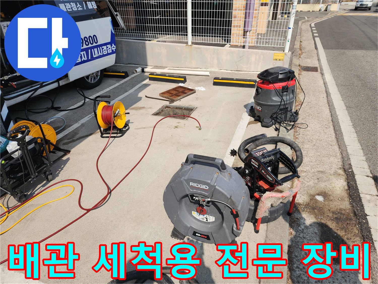 맨홀 주변에 배치된 고압 호스와 리지드 세척기 및 흡입 장비 세트