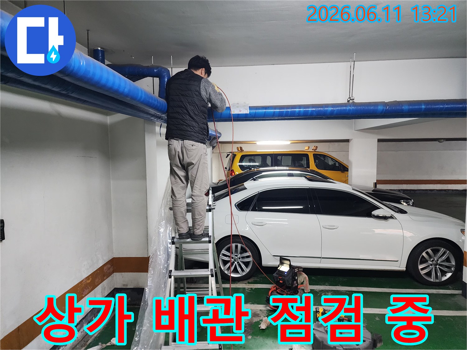 지하주차장 천장 파란색 배관을 대상으로 진행되는 고압 세척 작업